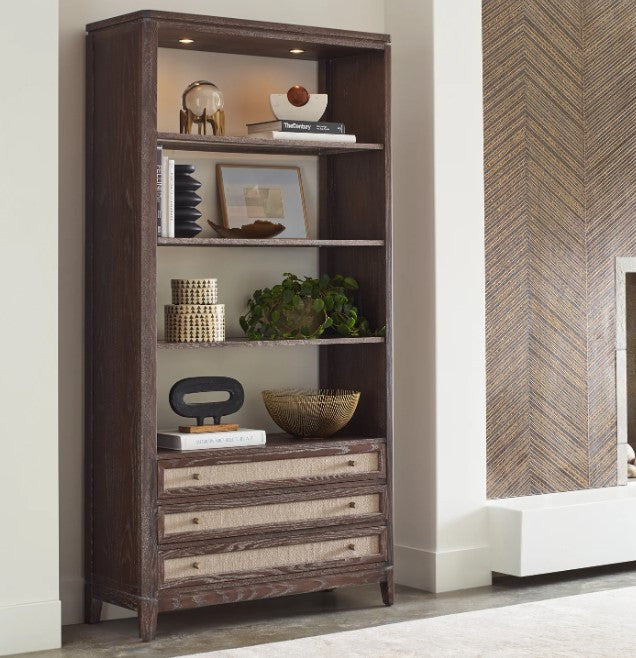 Wooden bookshelf with decorative items in a room with a chevron-patterned wall.