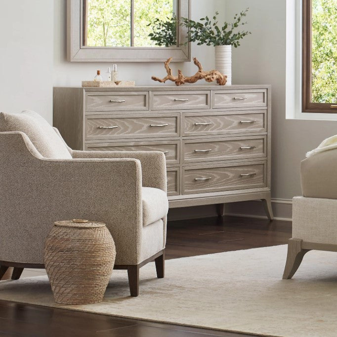 Living room with gray armchair, side table, and dresser.