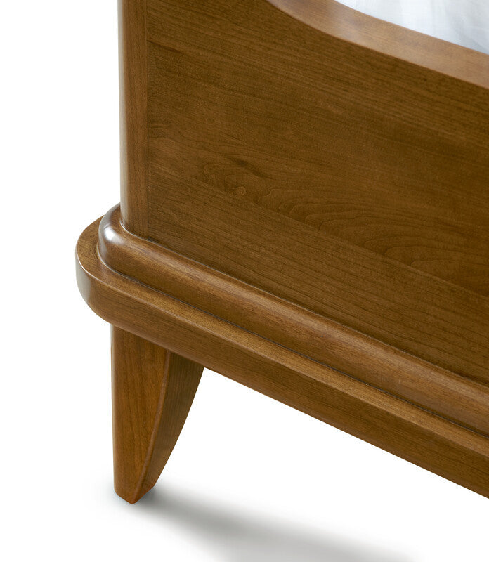 Close-up of a wooden bed frame with a white mattress.