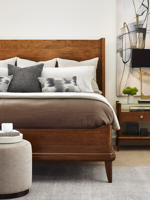 Wooden bed with bedding and pillows in a bedroom setting