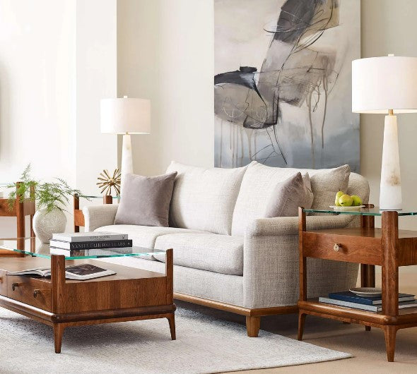 Living room with a gray sofa, wooden coffee table, and abstract art on the wall.