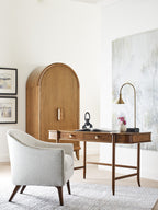 Modern home office with wooden desk, chair, and wall art.