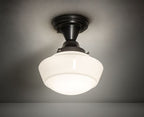Ceiling light fixture with white glass shade and black metal fixture on a gray background