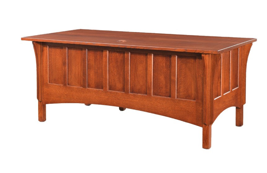 A wooden desk with a warm reddish-brown finish, featuring a paneled front and a slanted desktop, shown against a plain white background.