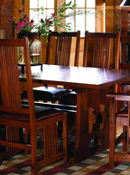 Wooden dining table with chairs in a room with large windows.