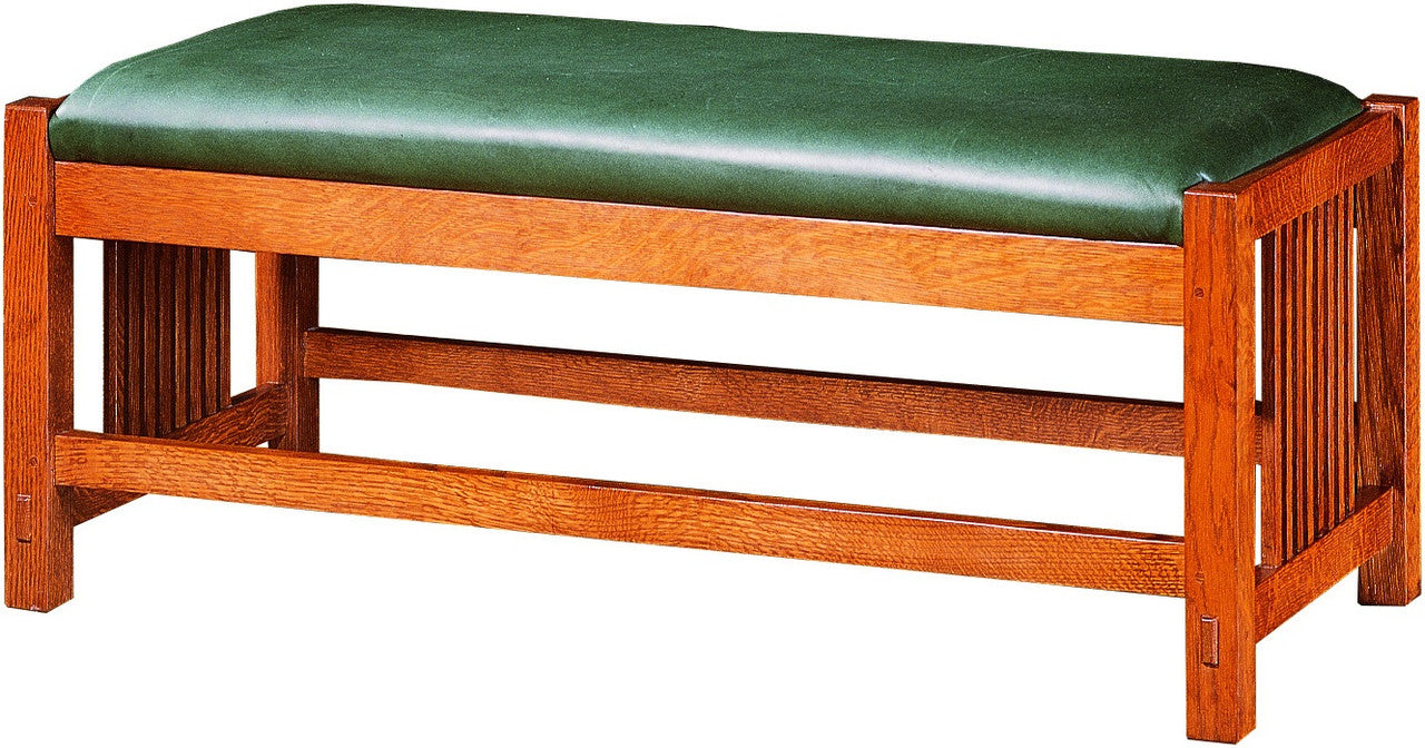 Mission-style Stickley oak bench with green cushion.