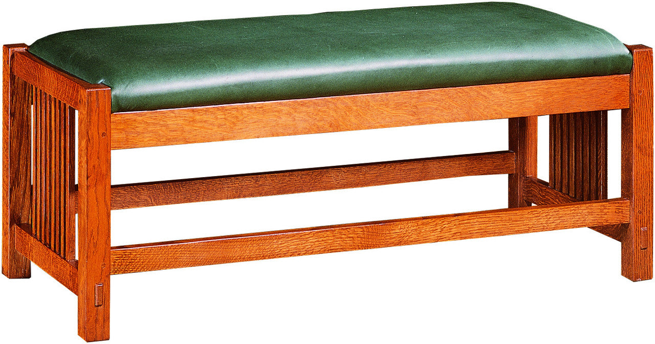 Mission-style Stickley oak bench with green cushion.