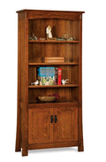 A tall wooden bookcase with three open shelves and two cabinet doors below, shown against a plain white background. The bookcase is made of medium brown wood with visible grain, and is styled with books, small figurines, and a bowl.