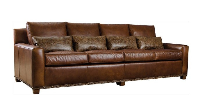 Brown leather sofa with decorative pillows on a white background