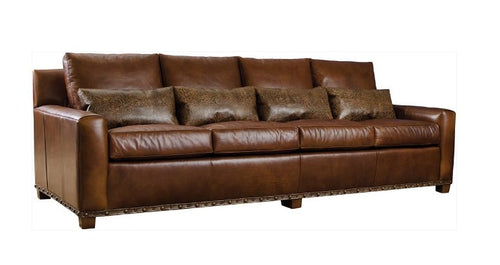 Brown leather sofa with decorative pillows on a white background