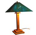 Table lamp with a green shade and wooden base on a white background