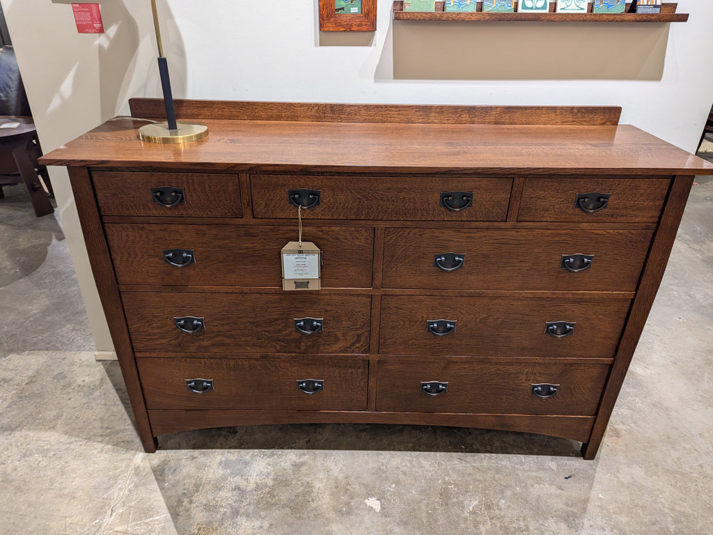 Harvey Ellis dresser with multiple drawers on a concrete floor