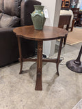 Stickley tea table with a green vase on top in a showroom setting
