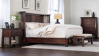 Wooden bed with white bedding in a bedroom setting with the park slope bench at the foot of the bed. 