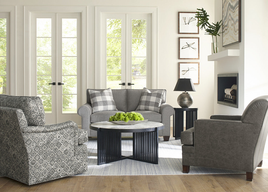Living room with gray sofa, armchair, and coffee table in a well-lit room.