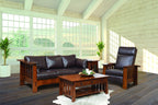 Living room with brown leather sofa and armchair, wooden coffee table, and large windows.