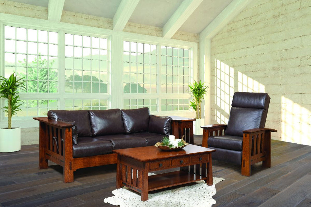 Living room with brown leather sofa and armchair, wooden coffee table, and large windows.