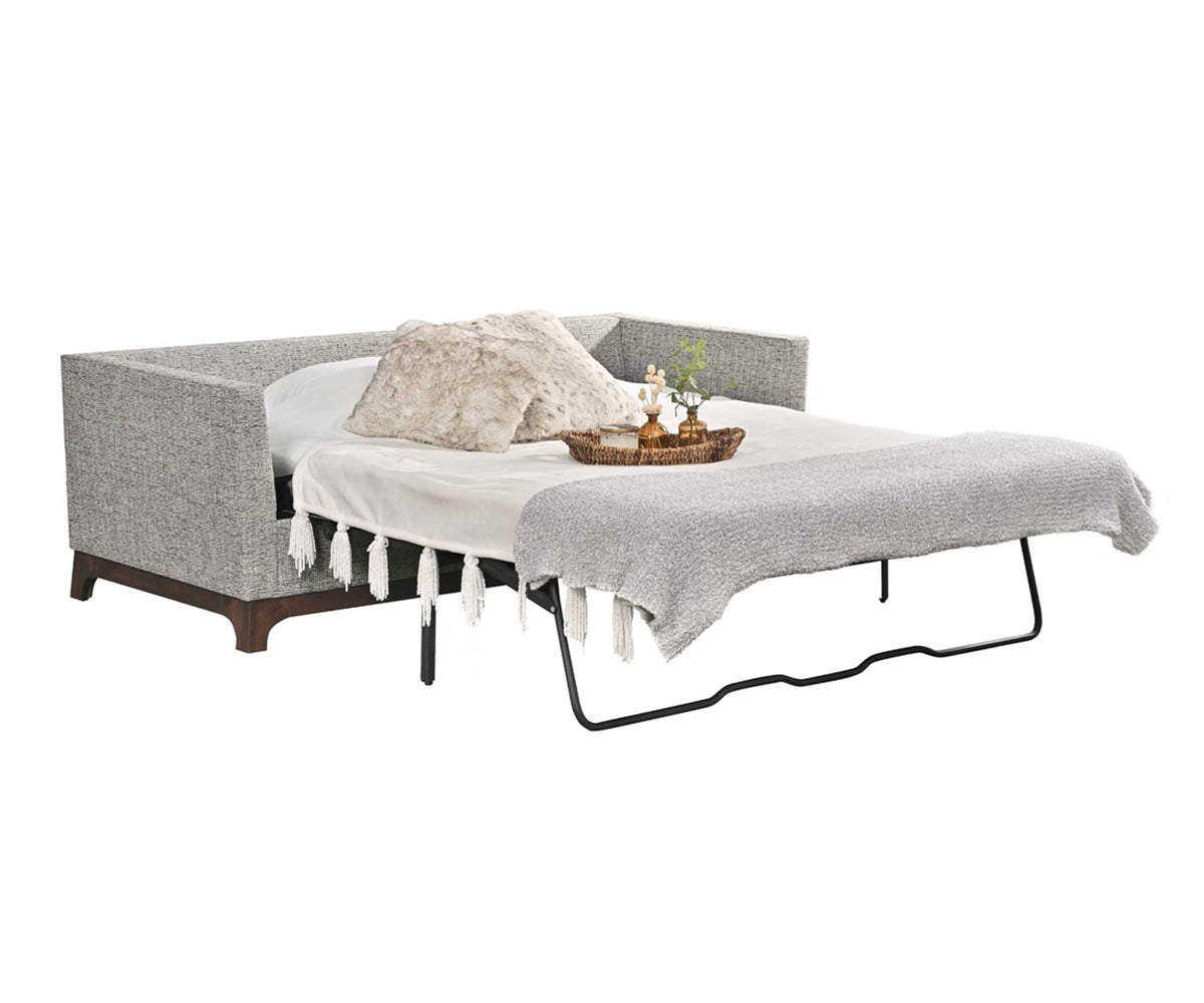 Sleeper sofa opened with mattress and bed sheets. 