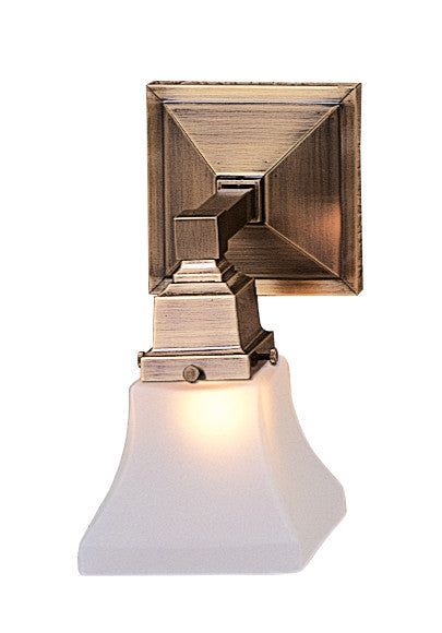 Brass wall sconce with a white glass shade on a white background