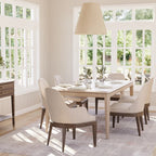 Dining room with a wooden table and chairs near large windows.