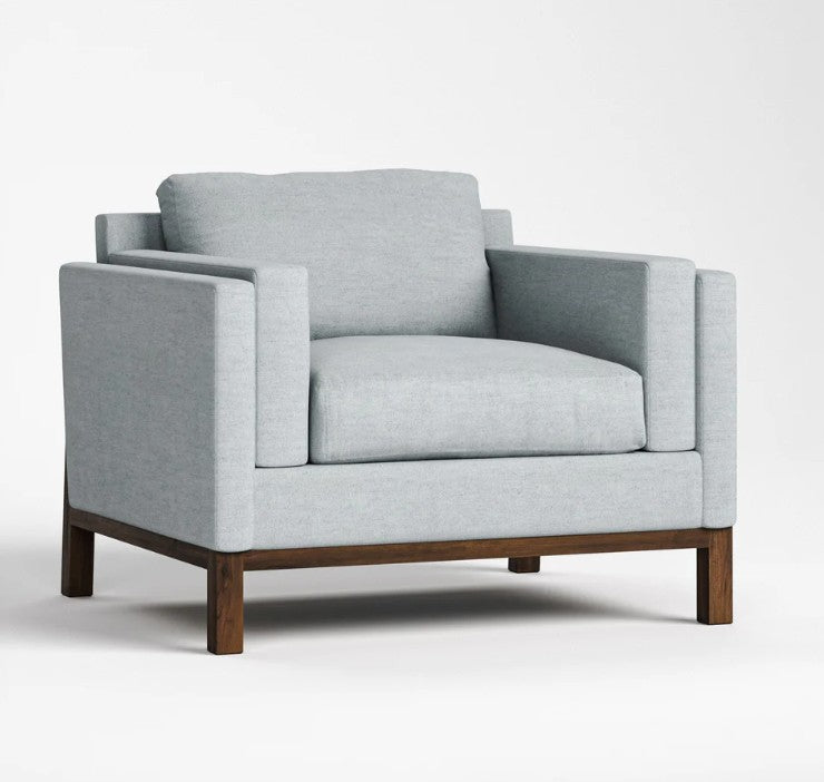 A light gray upholstered armchair with a dark wood base, shown from a three-quarter angle on a clean white studio background.