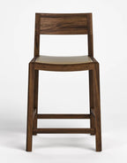 A modern wooden bar stool with a dark brown wood frame, a curved seat cushion, and a rectangular wooden backrest, shown against a plain white studio background.