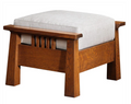 A wooden ottoman stool with a thick, square, light gray upholstered cushion on a medium brown wood frame, shown against a plain white background.