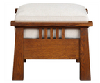 A wooden bench with a warm brown oak frame and a thick, light beige upholstered cushion on a white background.