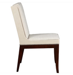 A high-back dining chair with cream upholstered seat and backrest, dark brown wooden legs, and silver nailhead trim along the front apron, shown against a plain white background.