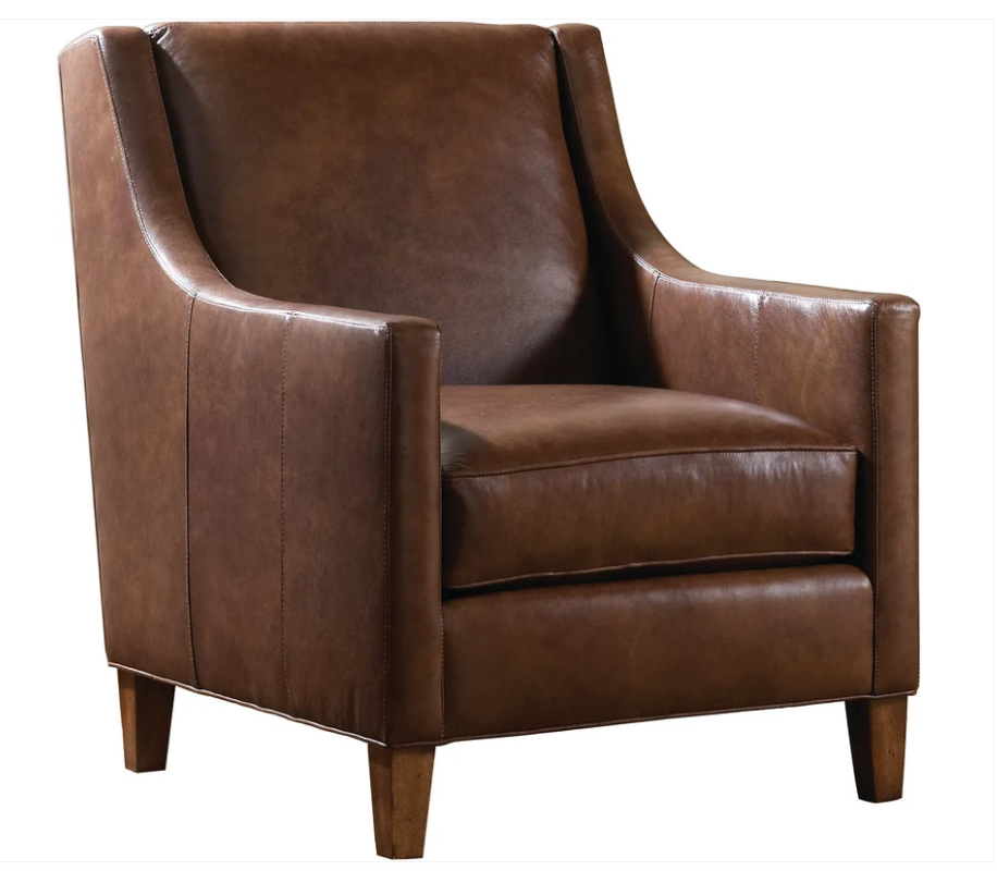 A brown leather armchair with a high back, wide armrests, and tapered wooden legs, shown against a plain white background.