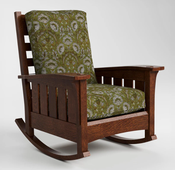 A wooden rocking chair with a dark brown frame and green patterned cushions, photographed on a light gray studio background.
