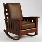 A classic wooden rocking chair with a dark brown leather cushioned seat and backrest, set against a plain light gray background.