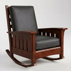 A classic wooden rocking chair with a dark brown wood frame and black faux-leather cushions, photographed against a neutral light gray background.