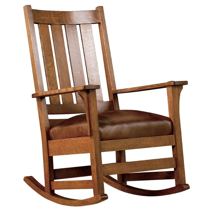 A classic wooden rocking chair with a warm medium-brown wood frame and a dark brown leather seat cushion, isolated on a white background.