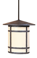 A hanging pendant light fixture with a dark textured metal frame and a warm cream-colored cylindrical shade, suspended by a dark rod against a plain white background.