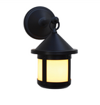A black outdoor wall sconce light fixture with a warm yellow glow, featuring a circular wall mount, decorative ring detail, and a lantern-style shade with vertical light panels.