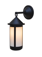 A black outdoor wall light with a cylindrical frosted glass shade, shown illuminated against a solid white background.