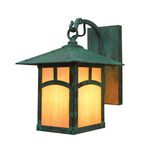 A square outdoor wall sconce with a dark green patina finish and warm orange glowing glass panels, shown against a plain white background.