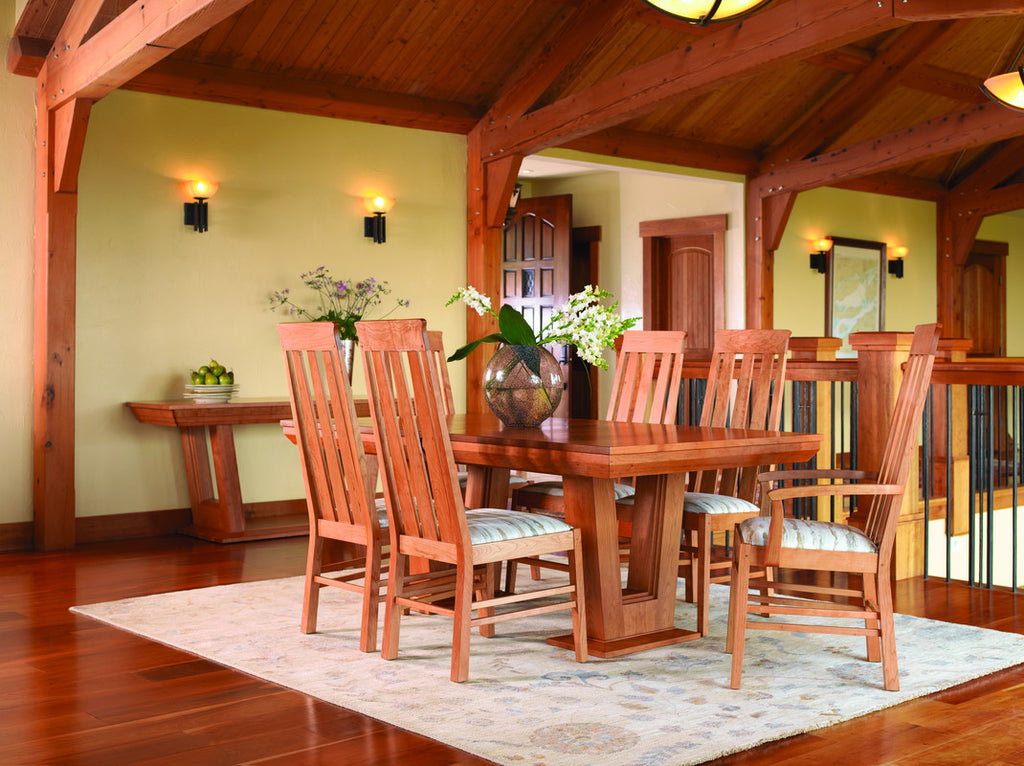 Wooden dining set with chairs in a room with wooden beams and a rug.