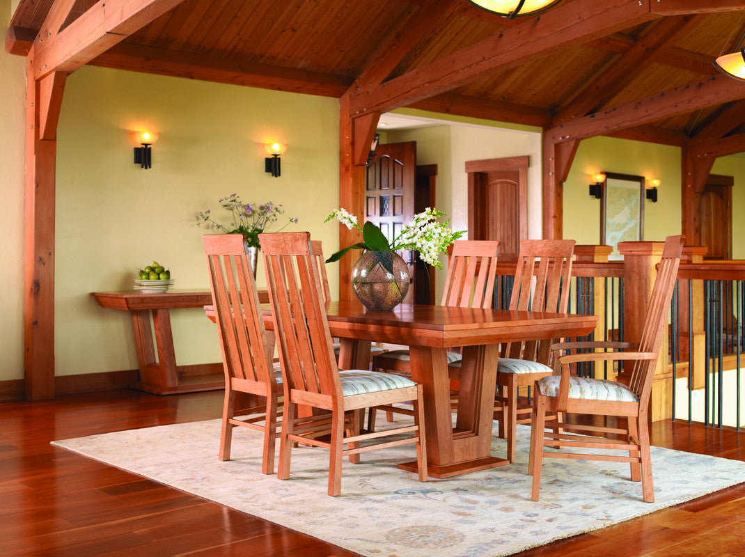 Wooden dining set with chairs in a room with wooden beams and a rug.