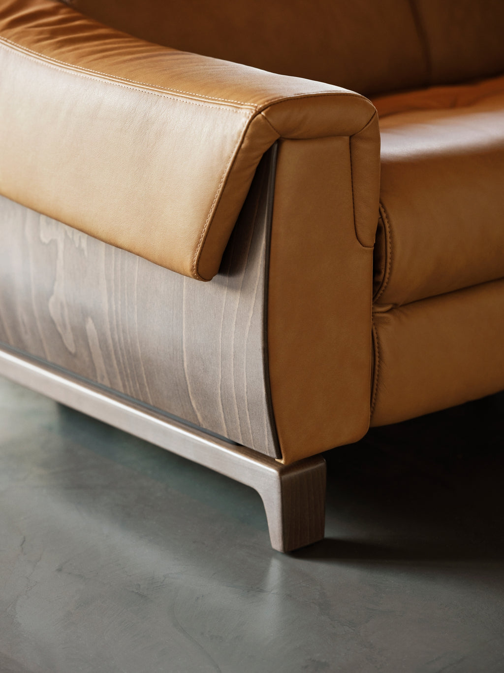 Close-up of the Stressless Anna A3 arm, wood side panel and walnut leg, shown in Paloma Taupe