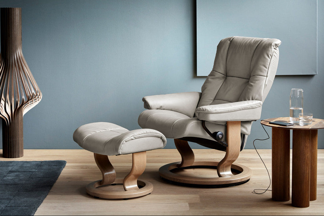Gray armchair with matching ottoman in a modern room setting.