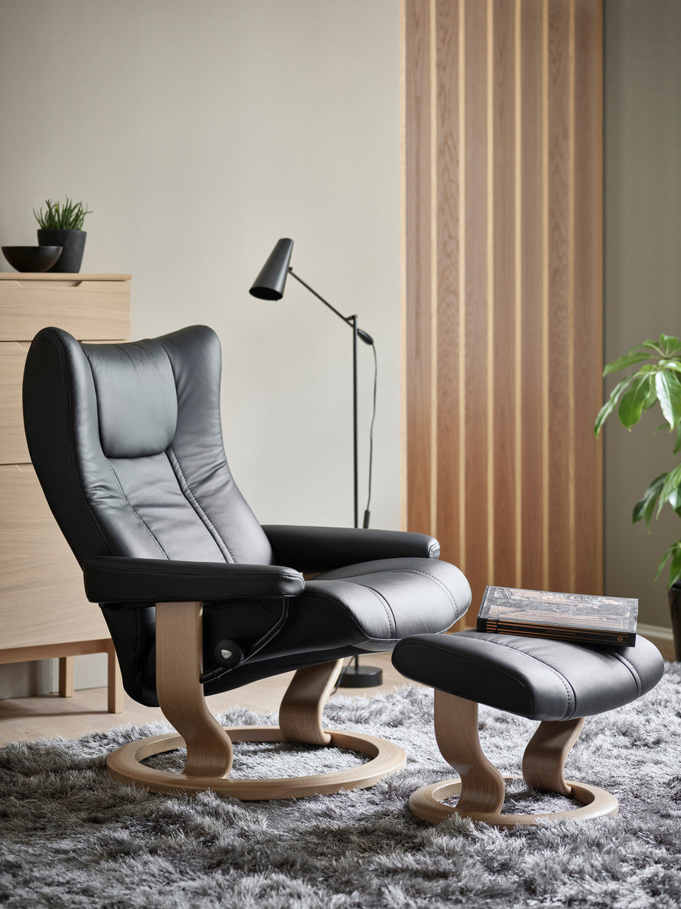 Gray recliner chair with ottoman in a modern living room setting