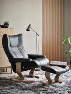 Gray recliner chair with ottoman in a modern living room setting