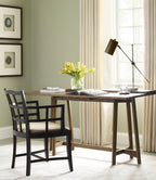 Home office with wooden desk, chair, and decor elements.