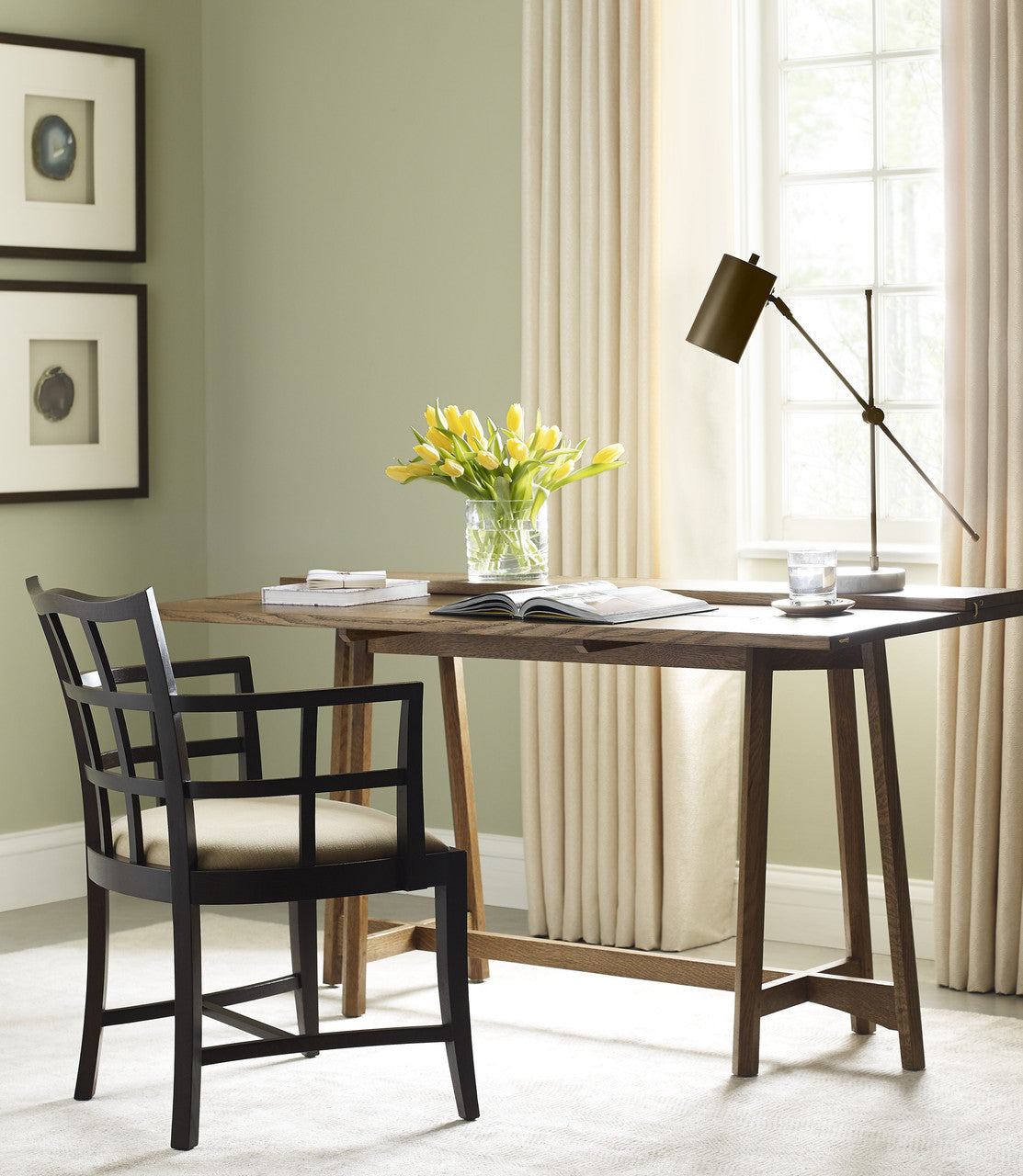 Home office with wooden desk, chair, and decor elements.