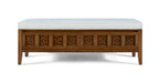 Wooden bench with decorative carvings and a white cushion on a white background