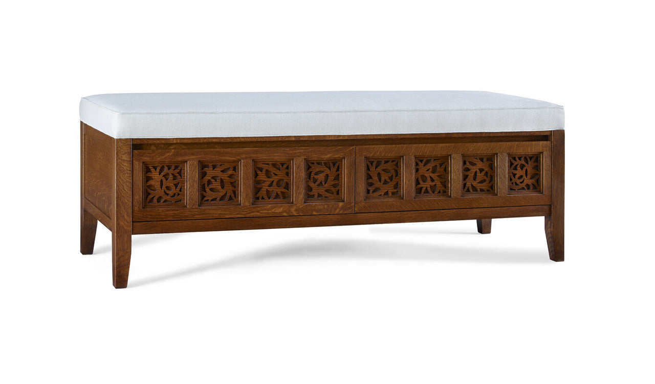 Wooden bench with decorative carvings and a white cushion on a white background