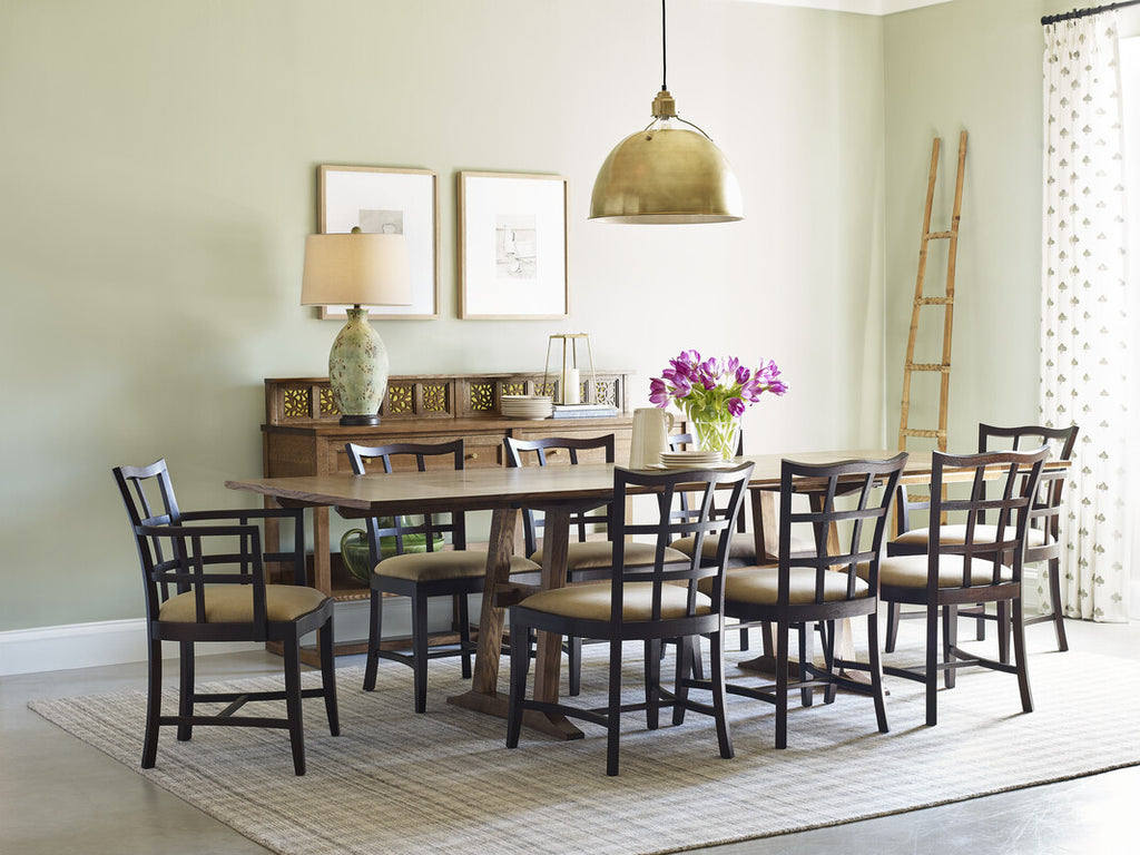 Dining room with wooden table and chairs, lamp, and decor items.