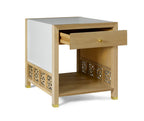 Wooden side table with a white drawer and decorative cut-out patterns on a white background